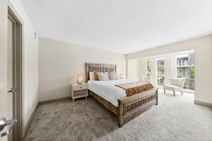 a white bedroom with a bed and a window at Beautiful Beachside Apartment With Marina View in Los Angeles
