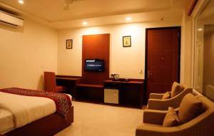 a hotel room with a bed and a chair and a television at Amer Valley in Jaipur