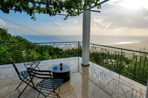 a balcony with a table and chairs and the ocean at Villa Ani in Borsh