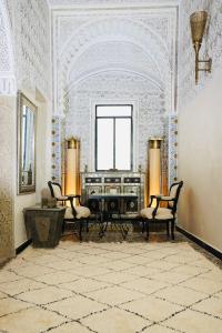 a room with two chairs and a piano in it at Riad Amelia - Lalla Amelia Room in Tetouan