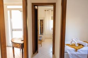 a room with a bed and a table and a mirror at Sicilian Oasi with exotic garden in Santa Maria Del Focallo