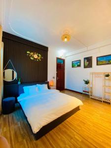 a large bedroom with a large bed with blue pillows at Ti Lau Homestay & Motorbikes in Ha Giang