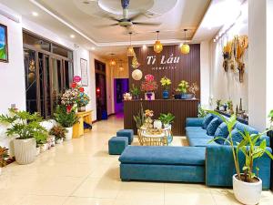 un hall de stockage avec des canapés bleus et des plantes dans l'établissement Ti Lau Homestay & Motorbikes, à Ha Giang