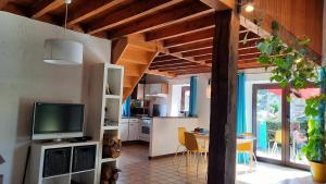 a living room with a television and a kitchen at Gîte rural Hubermont & Merveilles in Ortho