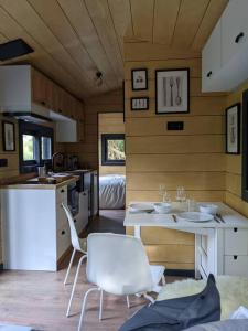 a kitchen with a table and chairs in a tiny house at Jungle Wagon - Ecovillage Hainburg in Hainburg an der Donau