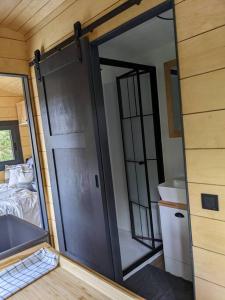 a sliding door in a tiny house with a bedroom at Jungle Wagon - Ecovillage Hainburg in Hainburg an der Donau