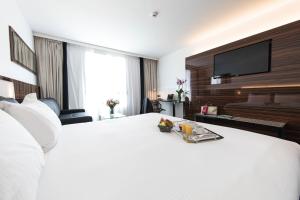 a hotel room with a large white bed with a flat screen tv at Westotel Tours Val de Loire in La Ville-aux-Dames