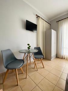 een eetkamer met een tafel en 2 stoelen bij Filoxenia Apartments in Mytilini