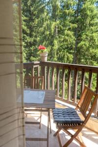 a porch with two chairs and a table and a flower pot at Bendida Park in Velingrad