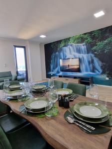 una mesa de comedor con platos y copas de vino en Absolut Vollga, en Durrës