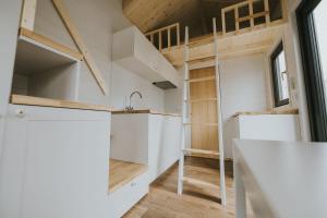 a tiny house with a kitchen and a loft at Tiny House mit Saunafass und Garten in Brensbach