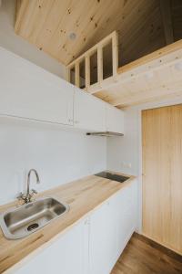 a kitchen with white cabinets and a sink at Tiny House mit Saunafass und Garten in Brensbach