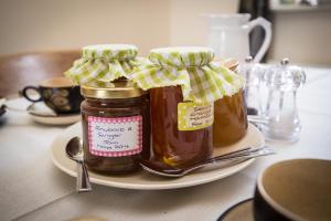 due barattoli di miele su un piatto su un tavolo di Crown Cottage Farm a Skipton