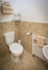 a bathroom with a white toilet and a sink at Crown Cottage Farm in Skipton