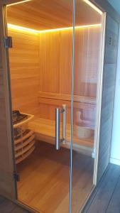 a sauna with a glass door in a room at Strandappartements Steinberghaff "Kegnæs" mit Meerblick und Sauna in Steinberg