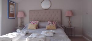 a bedroom with a white bed with towels on it at Samphire Cottage in Helston