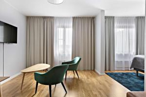 ein Hotelzimmer mit 2 grünen Stühlen und einem Bett in der Unterkunft Best Western Hotel Park Astoria in Enköping