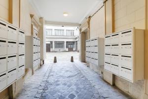 szereg szafek w pokoju z podłogą wyłożoną kafelkami w obiekcie Cozy studio - 2P - Gare de l'Est w Paryżu