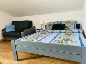 - un lit avec une couette bleue et un canapé dans l'établissement APARTAMENTY W BIESZCZADACH, à Berezka