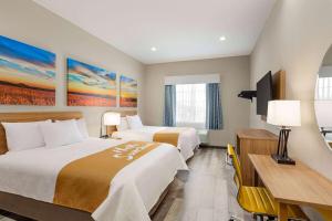Postel nebo postele na pokoji v ubytování Days Inn & Suites by Wyndham Greater Tomball