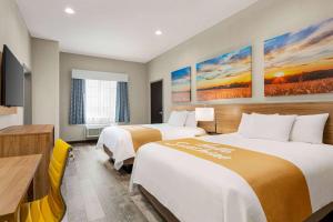 Postel nebo postele na pokoji v ubytování Days Inn & Suites by Wyndham Greater Tomball