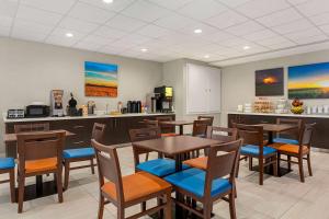 a restaurant with tables and chairs and a kitchen at Days Inn & Suites by Wyndham Greater Tomball in Tomball