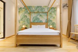 a bedroom with a canopy bed with a tropical wallpaper at Super OYO Capital O 1169 Le Grand Hanoi Hotel - The Charm in Hanoi