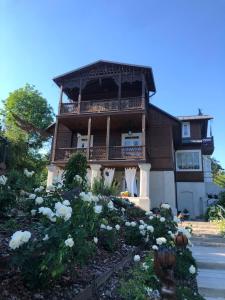 une maison avec un balcon et des fleurs devant elle dans l'établissement Willa Lucyna, à Nałęczów