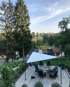 une terrasse avec un auvent bleu, des chaises et une table dans l'établissement Willa Lucyna, à Nałęczów