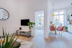 a white living room with a table and a tv at Lady on the Lane- 2 bed Primrose Hill in London