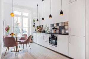 a kitchen with white appliances and a table with chairs at Lady on the Lane- 2 bed Primrose Hill in London