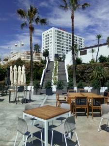 a patio with tables and chairs in front of a building at Sea and mountain view Room with pool- Habitación PISO COMPARTIDO para 1 persona in Benalmádena