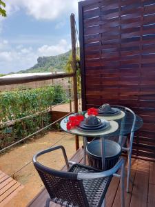 a table and two chairs on a deck with a view at Casinha do Cadu in Fernando de Noronha