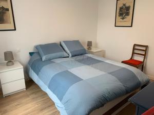 1 dormitorio con 1 cama grande y 1 silla en L'echappée briarde, en Marles-en-Brie