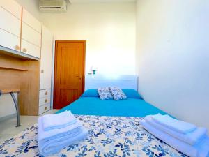 a bedroom with a blue bed with towels on it at Casa Samoa - Siracusa, fronte mare in Siracusa