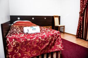 sypialnia z łóżkiem z czerwoną kołdrą w obiekcie Hotel Manhatan 