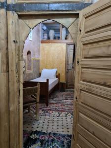 Un arco en una habitación con cama y mesa en Museum House - Dar Melyani en Fez