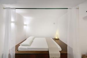 1 dormitorio con 1 cama con cortinas blancas en Aqua Holiday Apartments en Procida