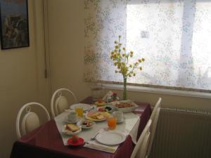 a dining room table with food and drinks on it at Onisillos Hotel in Larnaca