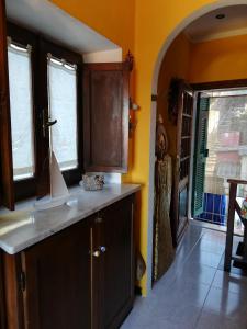 a kitchen with yellow walls and a counter top and windows at Ca' Tinetto in Fezzano