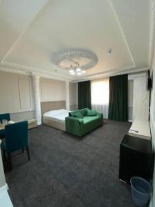 um quarto com uma cama e um sofá verde em Sapphire hotels em Taraz
