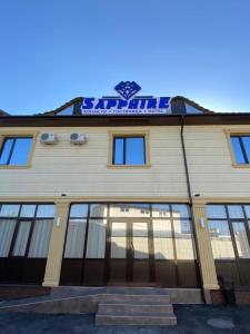 a building with a sign on the top of it at Sapphire hotels in Taraz
