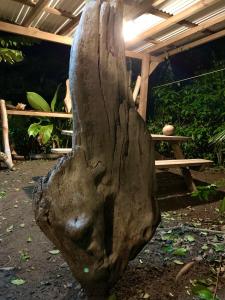 una estatua de una cabeza sentada en un patio en LODGE COLIBRIS vue panoramique mer et montagne pelée , 500 m plage dans un parc , Calme assuré Idéal pour découvrir le nord Caraïbes en Le Carbet