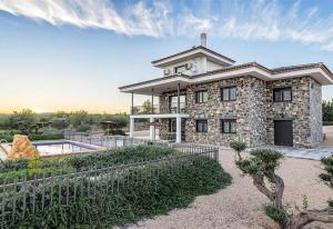 uma grande casa de pedra com uma piscina em frente em Casa Rural la Montana 1 em Chella