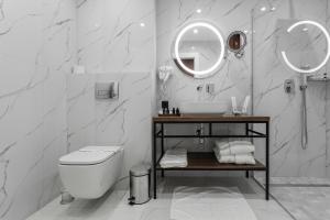 a bathroom with a toilet and a sink and a mirror at Riverwood Relax Park in Moshny