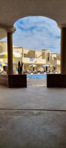 uma vista para um edifício com uma piscina e guarda-sóis em Hotel Beach Club la Perle em El Jadida