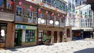 una calle en una ciudad con banderas y edificios en Apartamento Ático Select Real Caldas de Reis, en Caldas de Reis