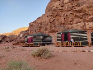 eine Person, die in einem Zelt in der Wüste sitzt in der Unterkunft Wadi Rum Desert Base Camp in Wadi Rum