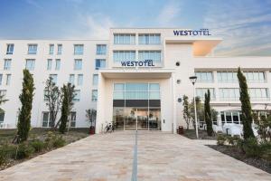 a white building with a sign on the front of it at Westotel Tours Val de Loire in La Ville-aux-Dames