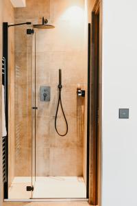 a shower with a glass door in a bathroom at Nepomuk rooms in Vipiteno